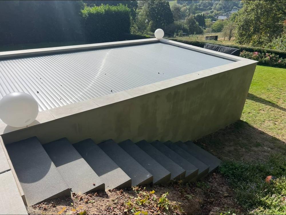 Piscine surélevée avec bâche à barres, escalier en pierre