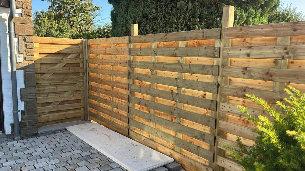 Clôture en bois le long d'une terrasse carrelée
