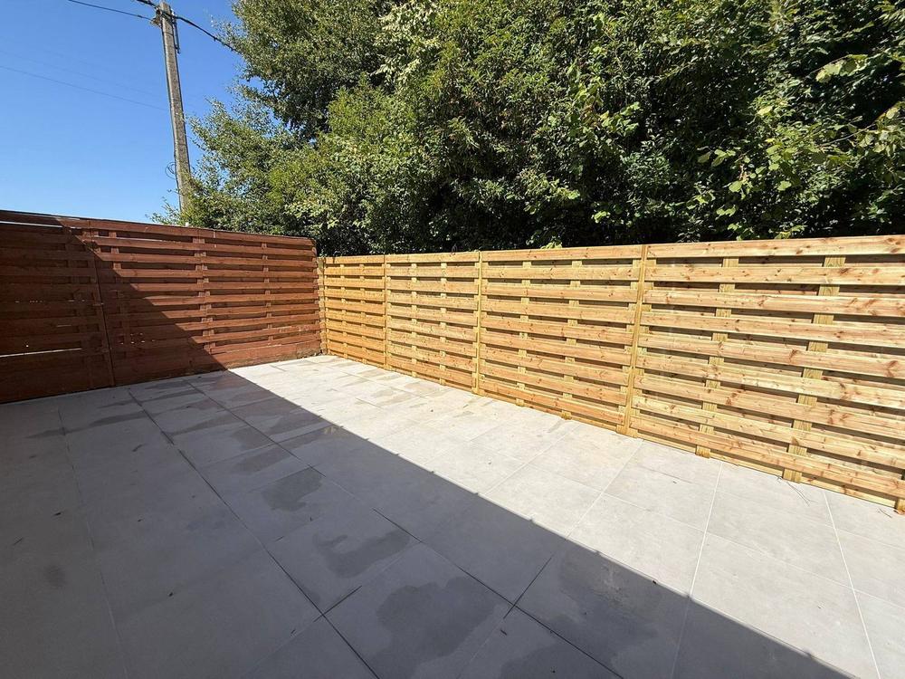 Angle de clôture en bois teinté et terrasse