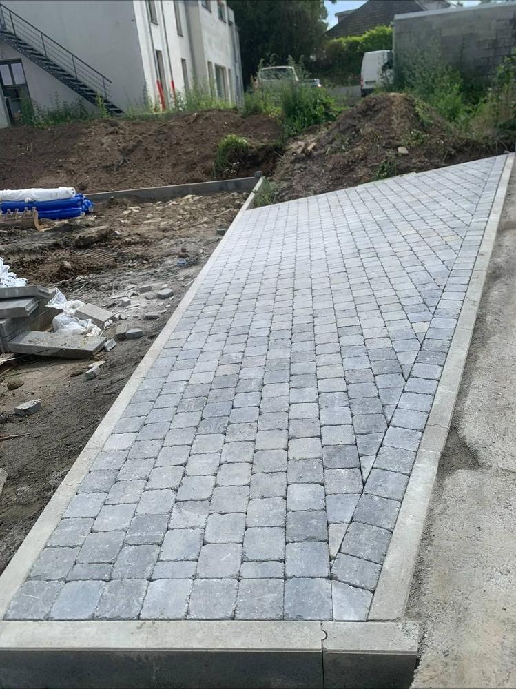 Allée en pavés en cours de pose, chantier en terre