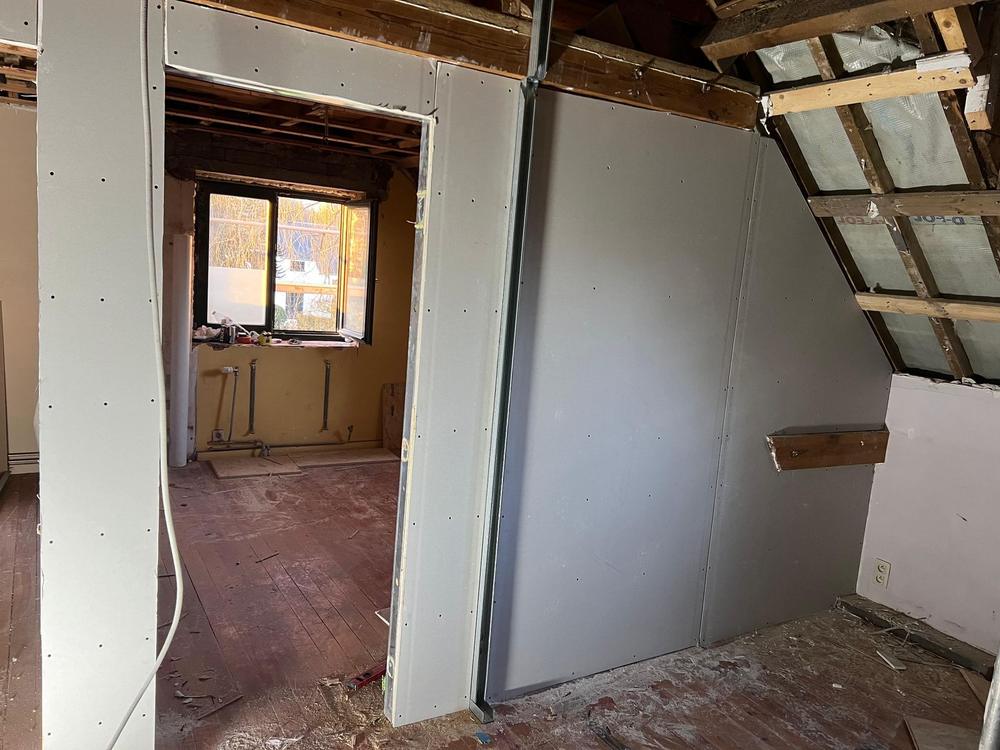 Cloison à ossature métallique avec porte, pièce en rénovation