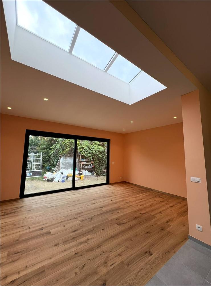 Extension rénovée, vue d'ensemble avec verrière de toit et baies vitrées sur jardin