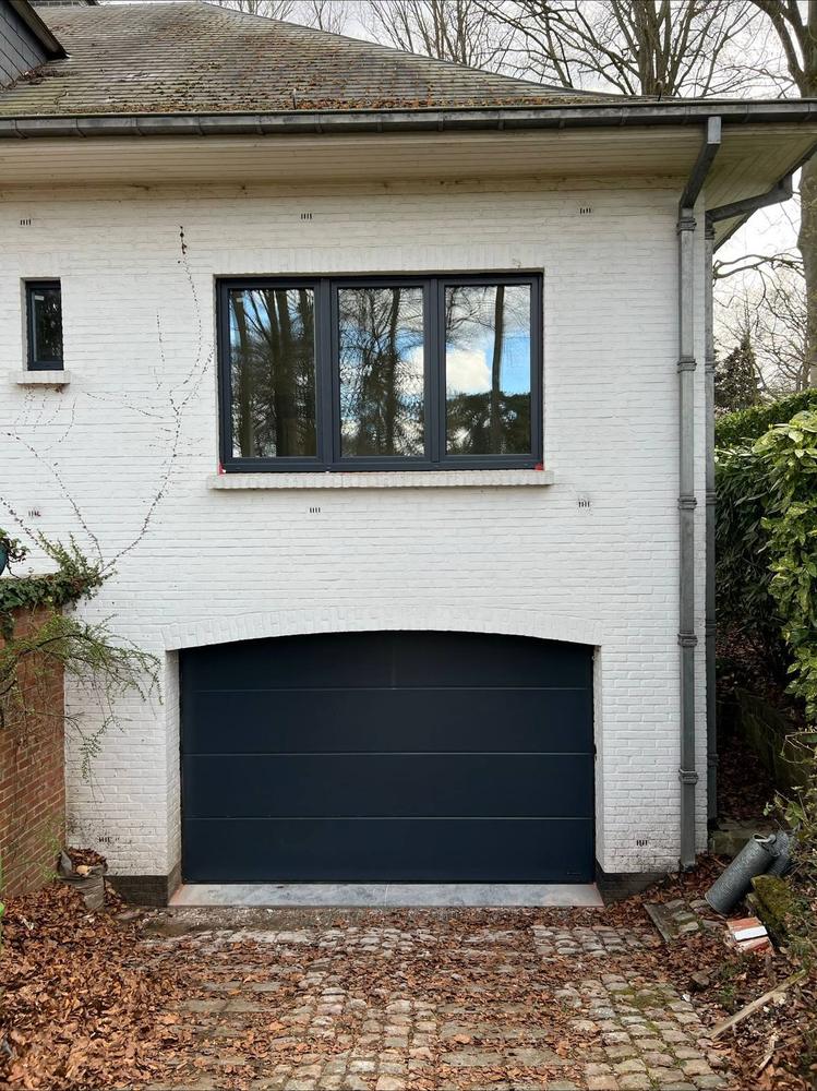 Porte de garage sectionnelle anthracite posée en façade blanche